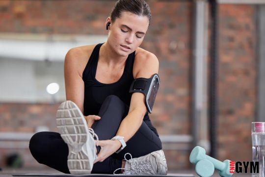 Female wearing fitness technology as she stretches after her workout