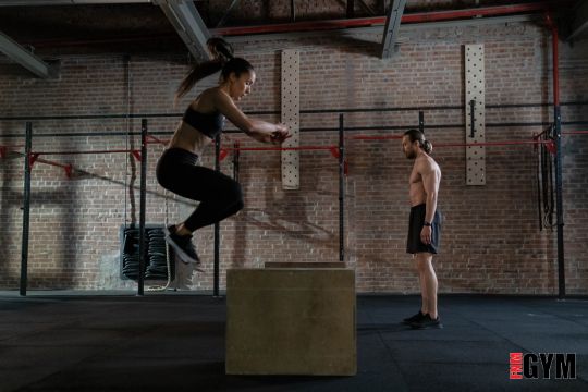 A woman doing box jumps in gym