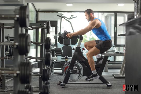 Male riding stationary bike in a fitness centre