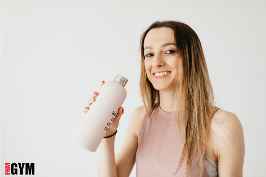 female with long hair in pink top with pink waterbottle